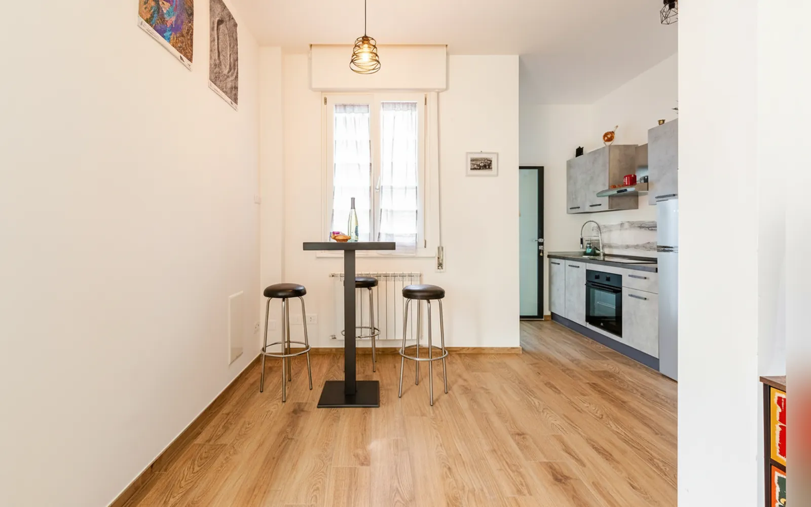 Il tavolo alto con gli sgabelli e la cucina sul fondo