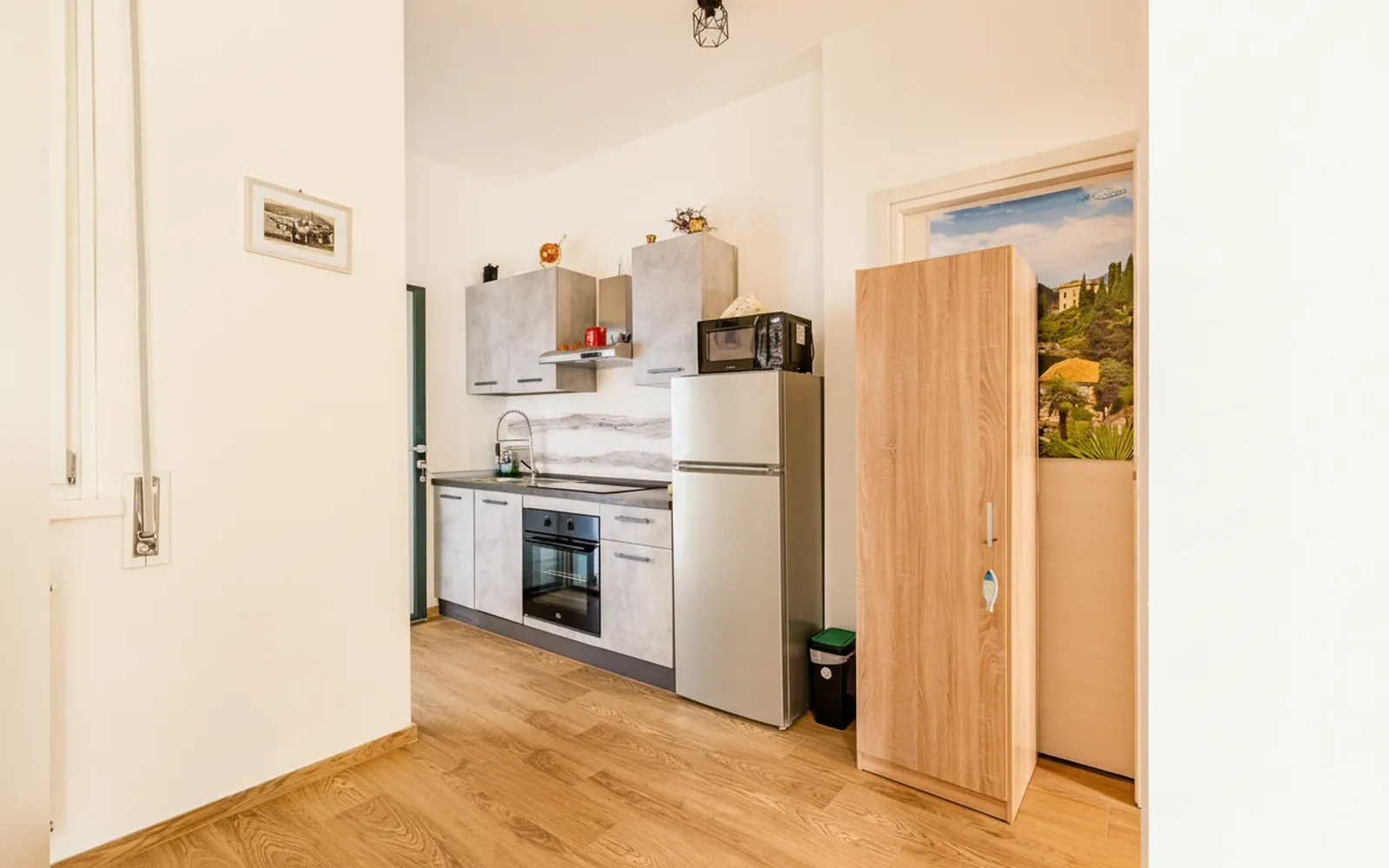 La cucina attrezzata con il frigorifero e l’armadio in legno