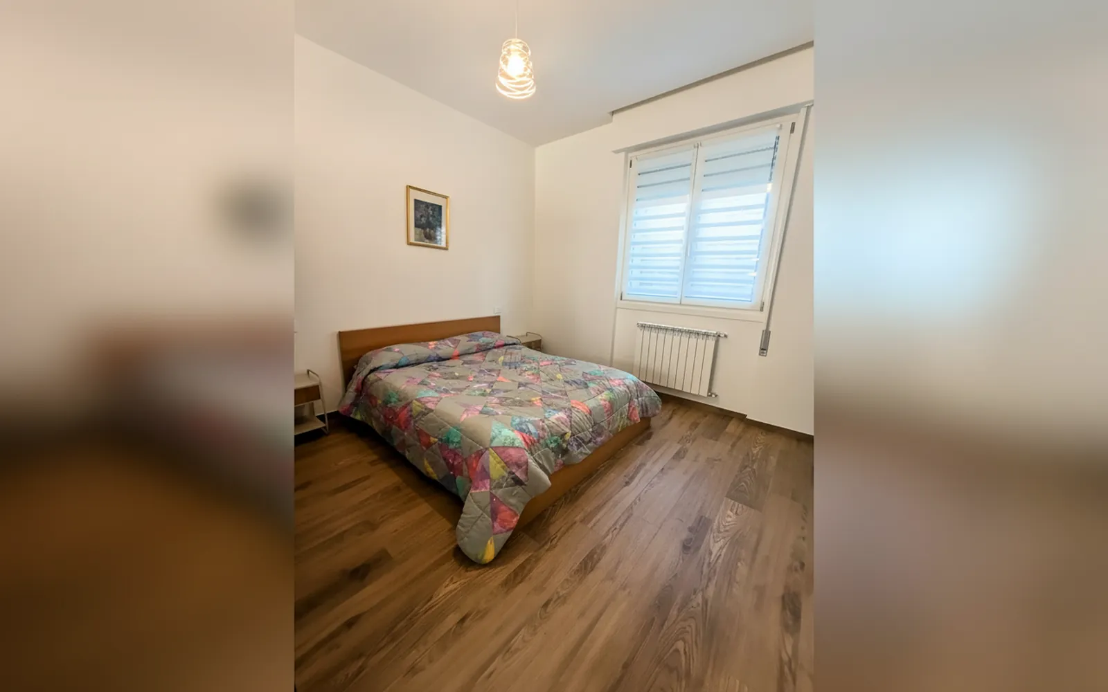 La camera da letto con il letto matrimoniale e la finestra